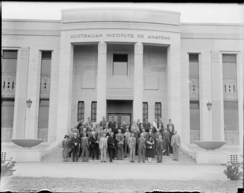 Group of men and women standing on the front steps of the Australian Institute of Anatomy, Canberra, ca. 1949, 2 [picture] / E.W. Searle