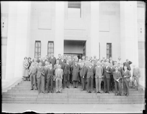 Close view of a group of men and women standing on the front steps of the Australian Institute of Anatomy, Canberra, ca. 1949 [picture] / E.W. Searle