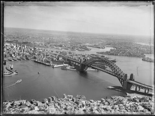 Aerial view of the Sydney Harbour Bridge and the southern approaches from the north, Sydney Harbour, ca. 1935 [picture] / E.W. Searle