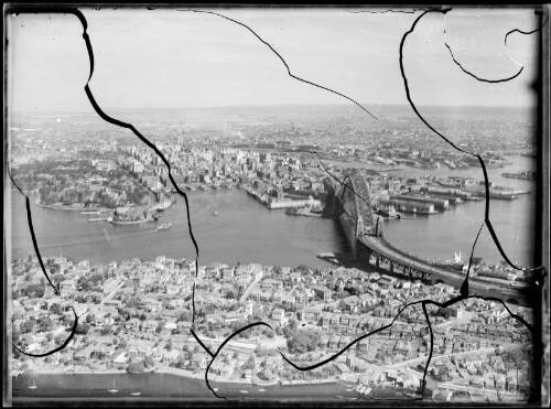 Aerial view of the Sydney Harbour Bridge and Circular Quay with Kirribilli in the foreground, Sydney Harbour, ca. 1935 [picture] / E.W. Searle