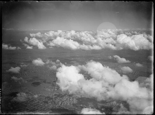 High altitude aerial view of clouds and an unidentified city, New South Wales, ca. 1945, 1 [picture] / E.W. Searle