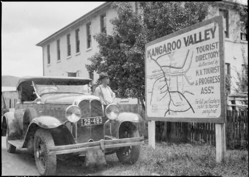 Car beside a tourist directory sign, Kangaroo Valley, New South Wales, ca. 1935 [picture] / E.W. Searle