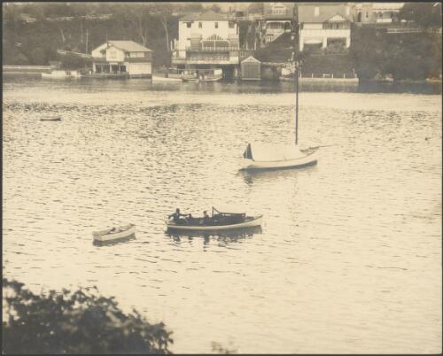 Two men in a boat in front of C. Rosman ferry terminal, Mosman Bay, Sydney Harbour, ca. 1925 [picture] / E.W. Searle