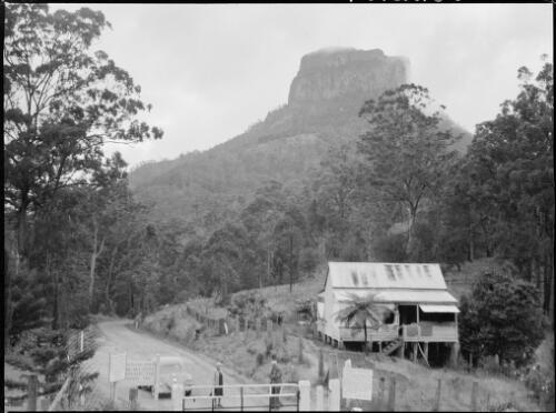 Mrs Searle and an unidentified person at the border gate on the Mount Lindesay Highway between Queensland and New South Wales, ca. 1949, 2 [picture] / E.W. Searle
