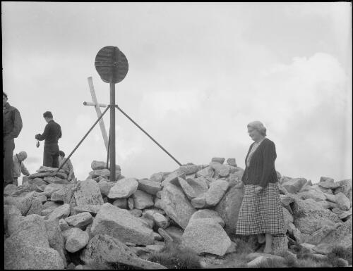Mrs Searle beside the trig point at the summit of Mount Kosciuscko [i.e. Kosciuszko], New South Wales, ca. 1949 [picture] / E.W. Searle