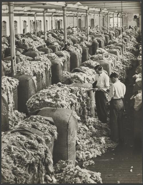 Buyers inspecting wool bales in a wool store, Sydney, ca. 1945 [picture] / E.W. Searle