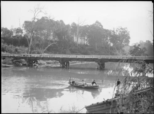 People in a rowing boat beside a wooden bridge, Australia, ca. 1945 [picture] / E.W. Searle