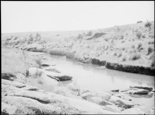 River passing through a treeless landscape, Australia, ca. 1935 [picture] / E.W. Searle