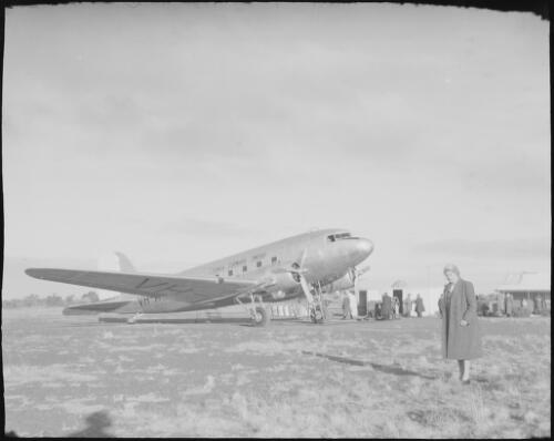 Mrs Searle standing in front of a Guinea Air Douglas DC 3, VH-AVK, Alice Springs, Northern Territory, 1947, 2 [picture] / E.W. Searle