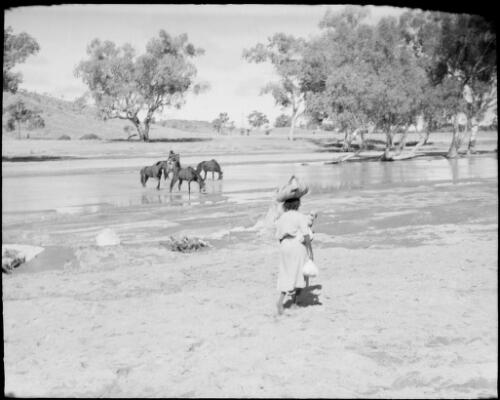 Laden woman walking beside the Todd River, Alice Springs, Northern Territory, 1947 [picture] / E.W. Searle