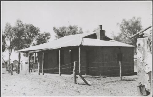 Building with a mug hanging from its eaves and a barbed wire fence, Northern Territory, 1947 [picture] / E.W. Searle