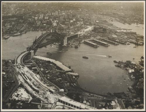 Aerial view of an incomplete Sydney Harbour Bridge with the northern approach in the foreground, Sydney Harbour, 1931 [picture] / E.W. Searle