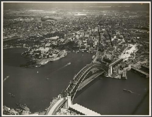 Aerial view of an incomplete Sydney Harbour Bridge from the north, Sydney Harbour, 1931, 1 [picture] / E.W. Searle