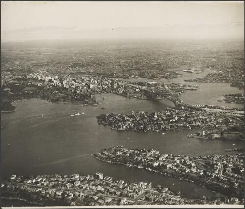Aerial view looking south west of an incomplete Sydney Harbour Bridge, Sydney Harbour, 1931 [picture] / E.W. Searle