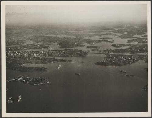 Aerial view looking west of an incomplete Sydney Harbour Bridge, Sydney Harbour, 1931 [picture] / E.W. Searle