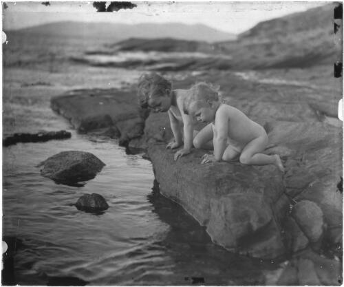 Allan and Dorian Searle on a rock ledge, Kangaroo Bay, Bellerive, Tasmania, ca. 1915, 2 [transparency] / E.W. Searle