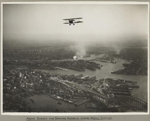 Aerial view of Sydney and the Harbour Bridge on the day of the official opening celebrations of the Sydney Harbour Bridge, 19 March, 1932 [picture] / E. W.  Searle