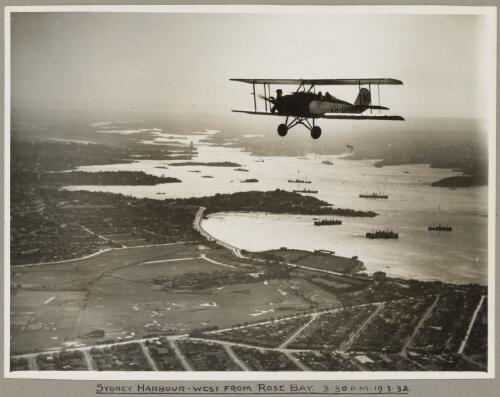 American Eagle model A-1 biplane VH-UHV in flight above Sydney Harbour, 19 March 1932 [picture] / E. W. Searle