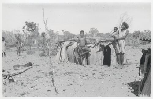 [Native family] in front of dwelling or humpy made of bark instead of corrugated iron on the beach of Umba Kumba, Little Lagoon, Groote Eylandt, May 1948 [picture] / Frank M. Setzler