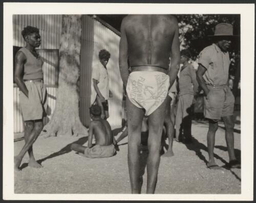 The use of old flour sacks for naga, or native costume, in front of Mission store, Milingimbi Island, August 1948 [picture] / Frank M. Setzler