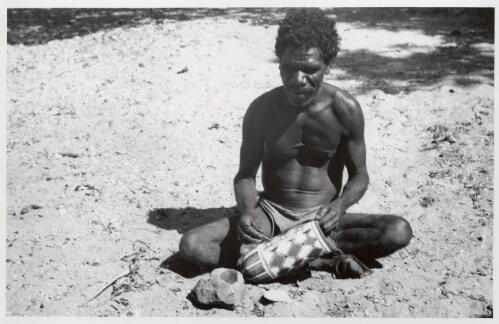 Decorating a man's dilli bag, tightly woven and painted white (kaolin), yellow and red (ochre), Millingimbi, [Northern Territory], August 1948] [picture] / Frank M. Setzler