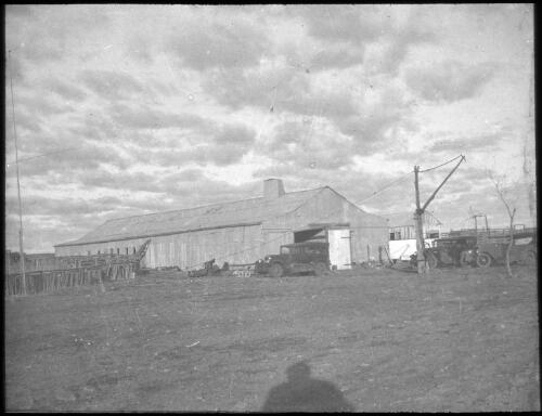 Large iron shed with three parked cars in front [transparency] : a deputation lantern slide of the AIM [Australian Inland Mission] Head Office, 1926-1940 / [John Flynn?]