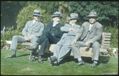 Four men seated on a garden bench [transparency] : a deputation lantern slide of the AIM [Australian Inland Mission] Head Office, 1926-1940 / John Flynn