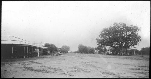 Dirt road through a town [transparency] : a deputation lantern slide of the AIM [Australian Inland Mission] Head Office, 1926-1940 / [John Flynn?]