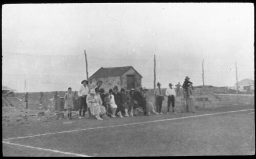 People grouped beside a tennis court [transparency] : a deputation lantern slide of the AIM [Australian Inland Mission] Head Office, 1926-1940 / [John Flynn?]
