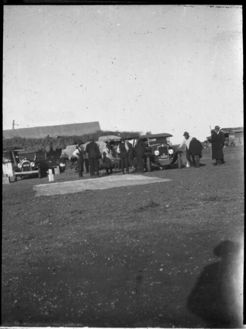 Group of men gathered around cars [transparency] : a deputation lantern slide of the AIM [Australian Inland Mission] Head Office, 1926-1940 / [John Flynn?]