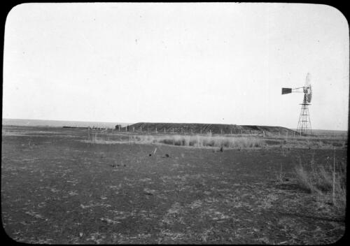 Windmill in the outback [transparency] : taken on survey trip undertaken in 1927 by Rev. J.A. Barber and Dr. George Simpson for the Flying Doctor Scheme