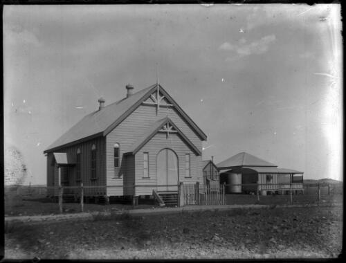 Unidentified weatherboard church with houses in the background [1] [picture] : Fred McKay Cape York Peninsula and West Queensland Patrol 1938-1940 / [Fred McKay]