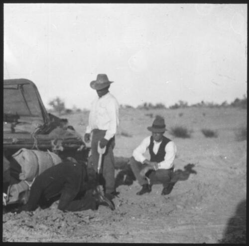 Car bogged on dirt track, three unidentified men next to car [transparency] : miscellaneous glass slide / [John Flynn?]