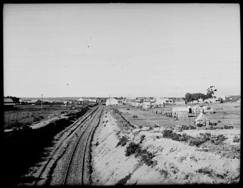 Railway line passing through a rural town [picture] : Fred McKay Cape York Peninsula and West Queensland Patrol 1938-1940 / [Fred McKay]