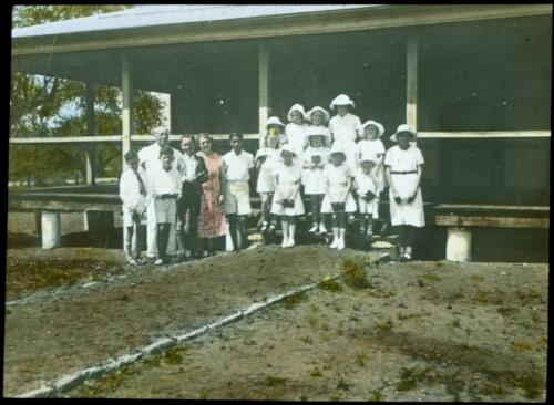 Students and staff standing in front of Broome School [transparency] : a lantern slide used in lectures on all Australian Inland Mission activities, 1940- / [John Flynn?]