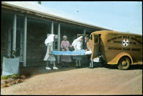 Patient being taken from ambulance into hospital at Leigh Creek [transparency] : a lantern slide used in lectures on all Australian Inland Mission activities, 1940- / [John Flynn?]