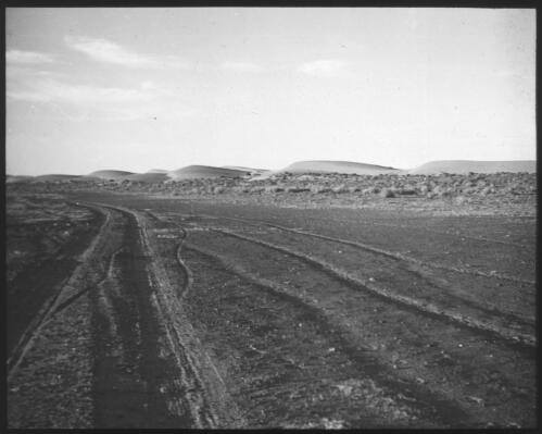 Tyre tracks across desert landscape, South Australia [transparency] : scene of mid-north South Australia used by Rev. F.H. Patterson on Stuart Patrol 1930+