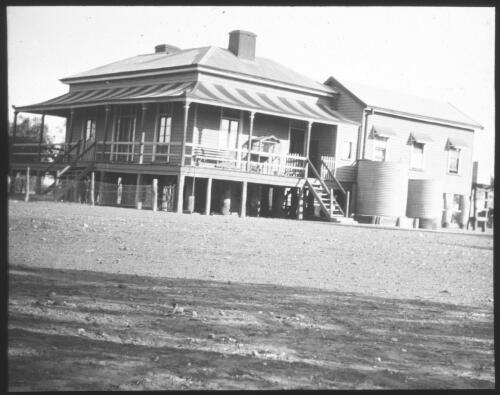 Unidentified building with two rainwater tanks [transparency] : lantern slide used by Rev. F.H. Paterson, north South Australia / [John Flynn?]