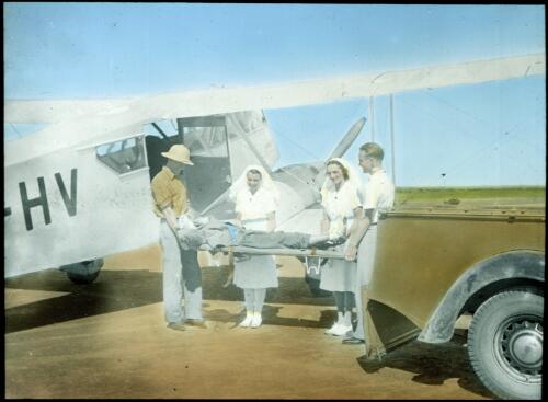 Patient being taken off plane [transparency] : a lantern slide used in lectures on all Australian Inland Mission activities, 1940- / [John Flynn?]