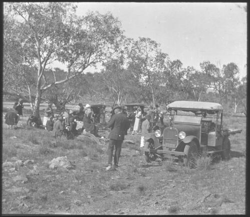 Group of unidentified people and three cars at a picnic? [transparency] : lantern slide used by Rev. F.H. Paterson, north South Australia / [John Flynn?]