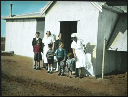 Nurses and children outside the hospital [transparency] : a lantern slide used in lectures on all Australian Inland Mission activities, 1940- / [John Flynn?]