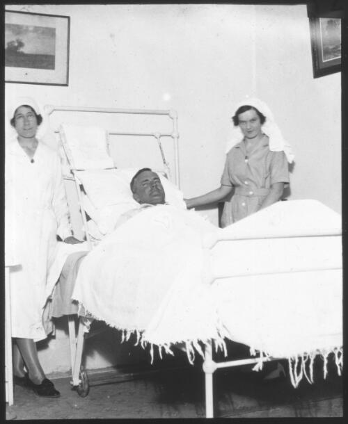 Sister A. Jaffer and Sister W. Crouch with a patient, Beltana Hospital, South Australia [transparency] : part of South Australian and other AIM [Australian Inland Mission] scenes used by Rev. F.H. Patterson