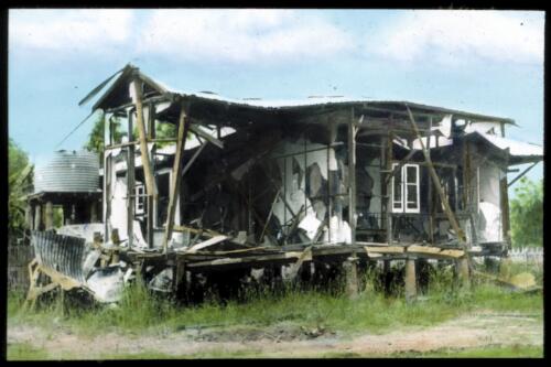 Wooden house, badly damaged [transparency] : a lantern slide used for publicity in South Australia / [John Flynn]