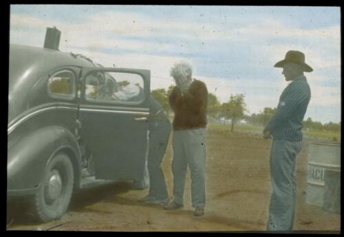 Three unidentified men and a car [transparency] : a lantern slide used for publicity in South Australia / [John Flynn]