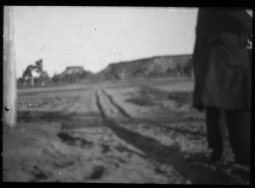 Man looking down a road towards mountains [transparency] : a lantern slide used for publicity in South Australia / [John Flynn]