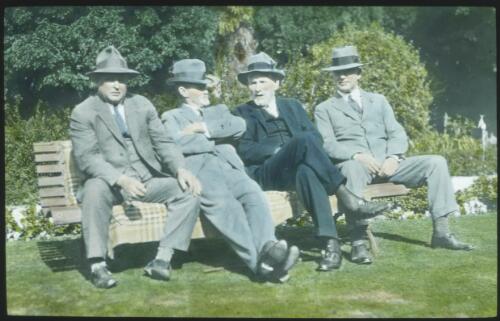 Kidman?, four unidentified men in suits and trilbies, sitting on a park bench [transparency] : part of South Australian and other AIM [Australian Inland Mission] scenes used by Rev. F.H. Patterson