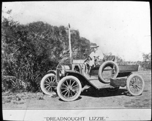 "Dreadnought Lizzie"- early car with a driver and a dog [transparency] : inland people and general scenes / [John Flynn?]