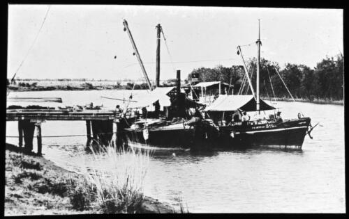 Two fishing boats moored at jetty on an unidentified river [transparency] / [John Flynn?]