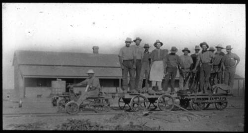 Road gang standing on a rail cart [transparency] : a lantern slide used by John Flynn in lectures / [John Flynn]
