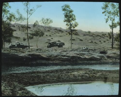 Unidentified group of people and two cars by river [transparency] / [John Flynn?]